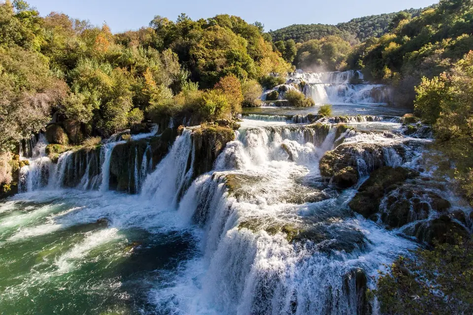 Skradinski Buk waterfalls in Krka National Park, wide cascades tumbling over mossy travertine steps into a green pool