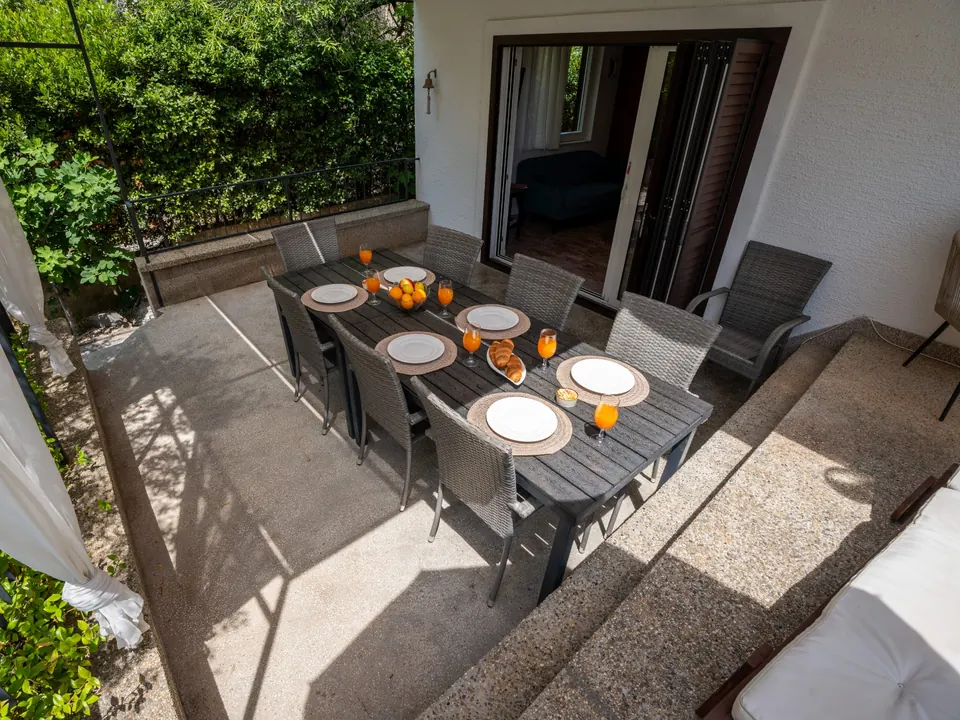 The outdoor dining table laid for eight, seen from the balcony above
