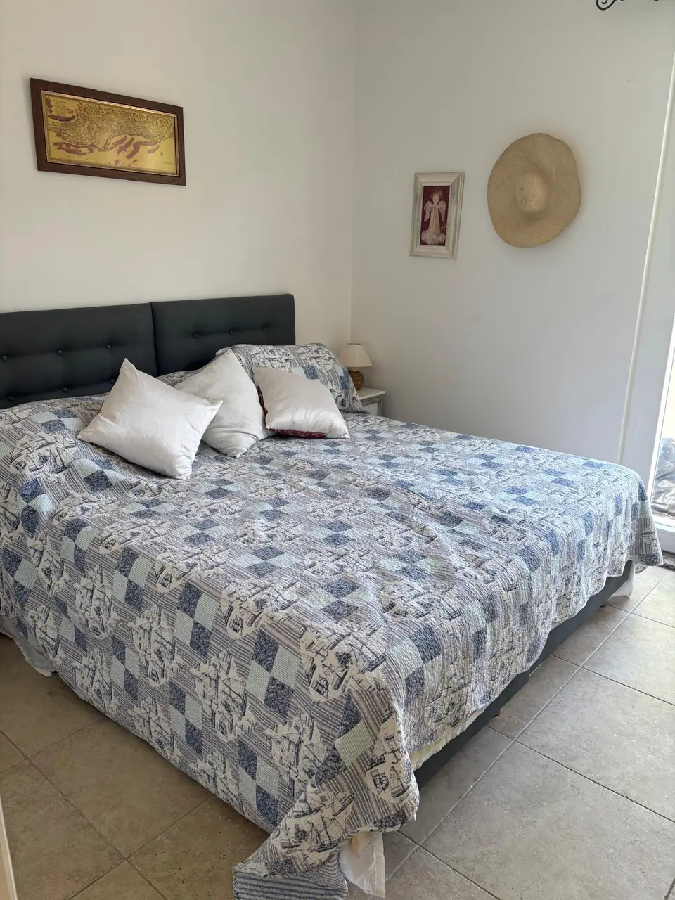 Bedroom with a double bed, grey headboard and blue patchwork quilt
