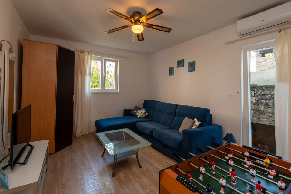 Downstairs games room with a table football table and a blue sofa