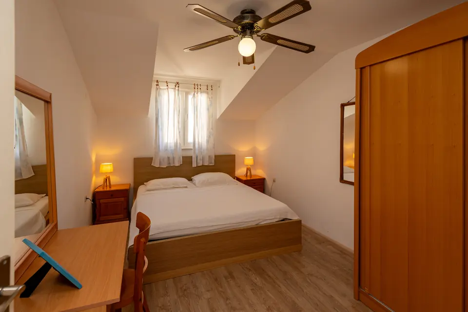 Bedroom with a double bed, wardrobe and ceiling fan