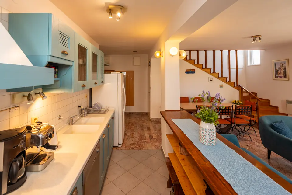 The kitchen and the long wooden dining table, with the staircase behind