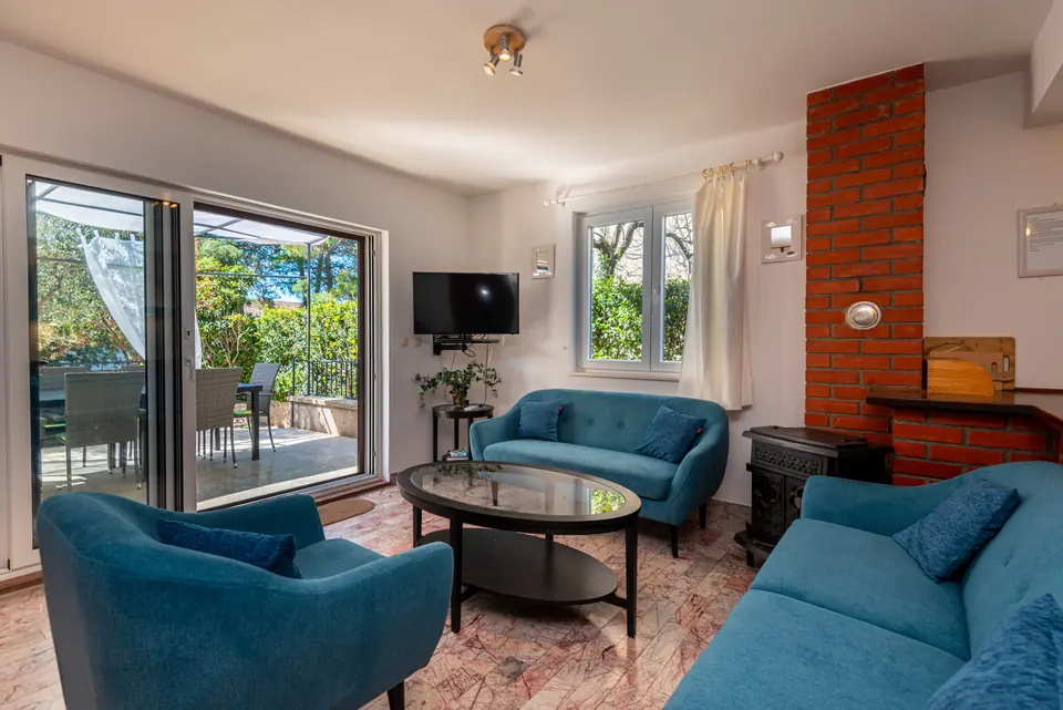 Sitting area with a blue sofa and armchairs beside the terrace doors