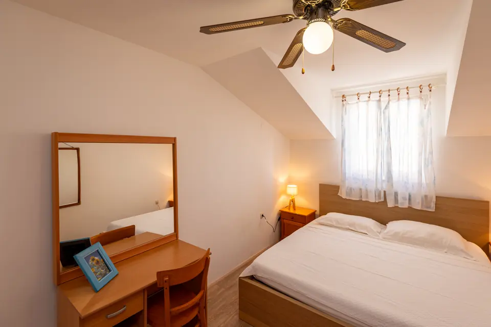 Bedroom with a double bed, writing desk and ceiling fan